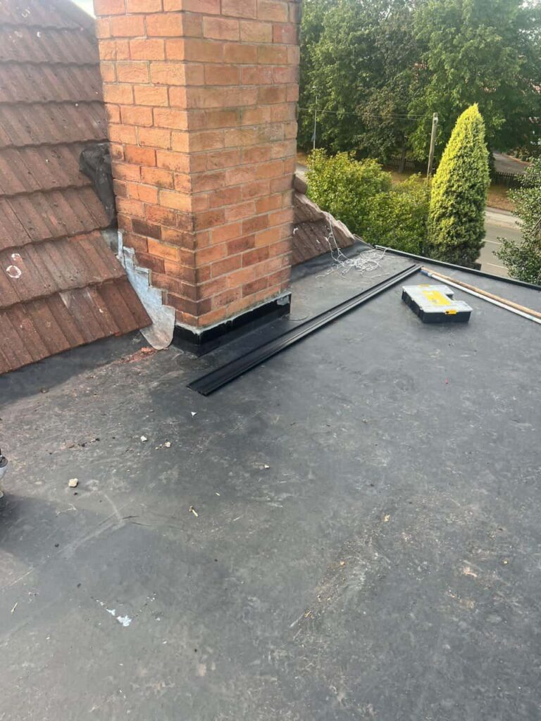 This is a photo of a flat roof which has just been repaired, there is also a chimney stack and some leadwork has also been dressed. Works carried out by Tipton Roofing Repairs